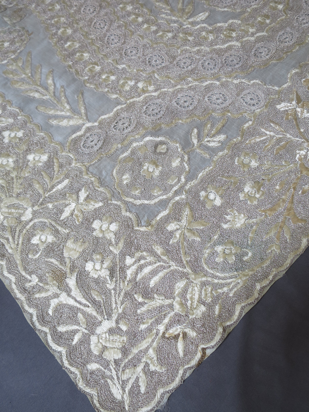 Elegant corner view of a 180x200cm antique Indian Zardozi panel, showing dense silver-gilt wire embroidery on sheer silk gauze.
