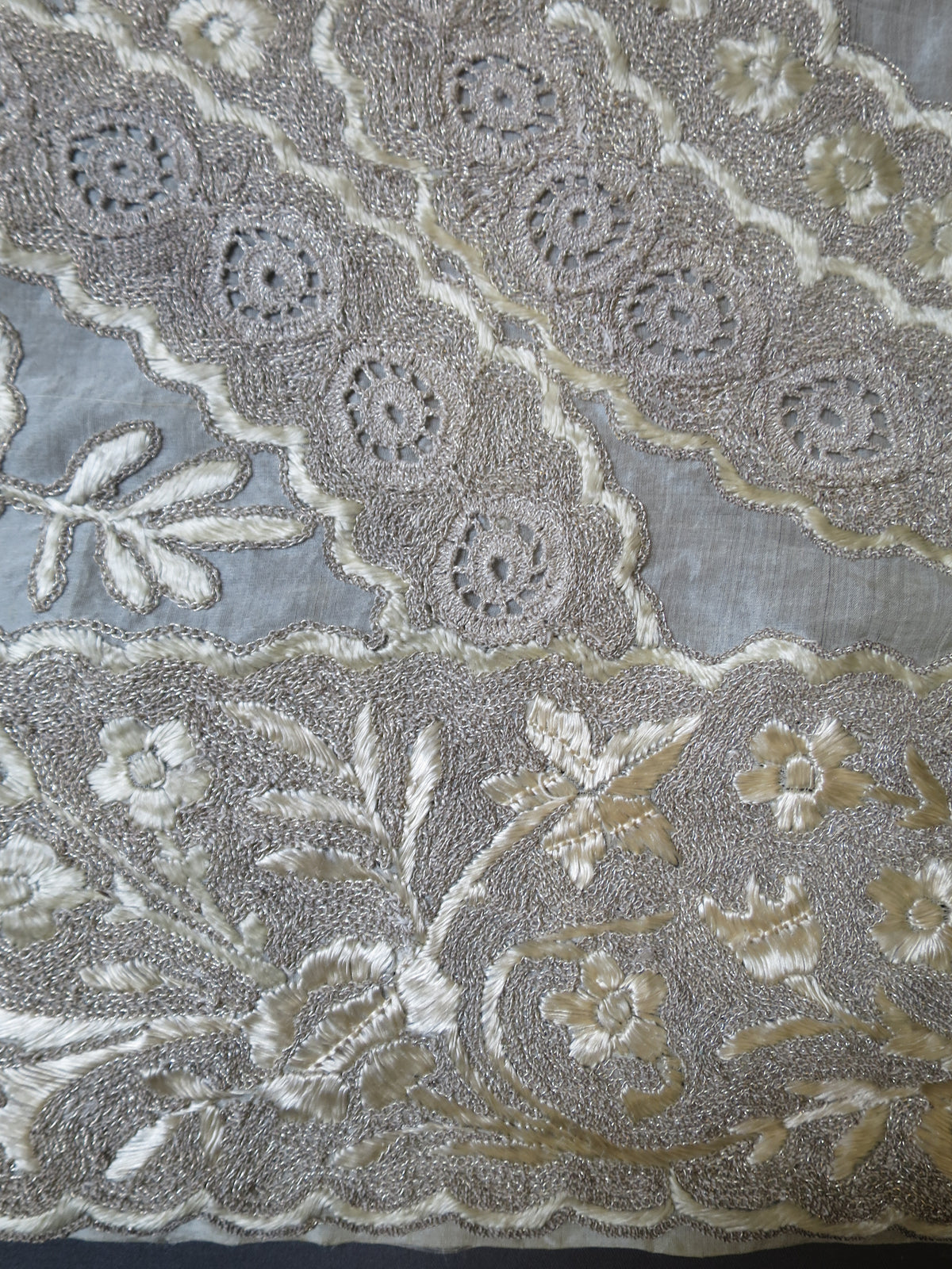 Scalloped border on an antique Indian Zardozi blanket highlighting satin-stitched flowers and metallic purla wirework.