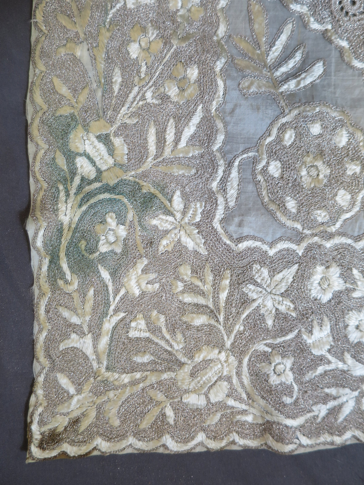 Small spots of green verdigris copper oxidization on the genuine gilt-copper wire of a vintage Indian metal embroidery panel.