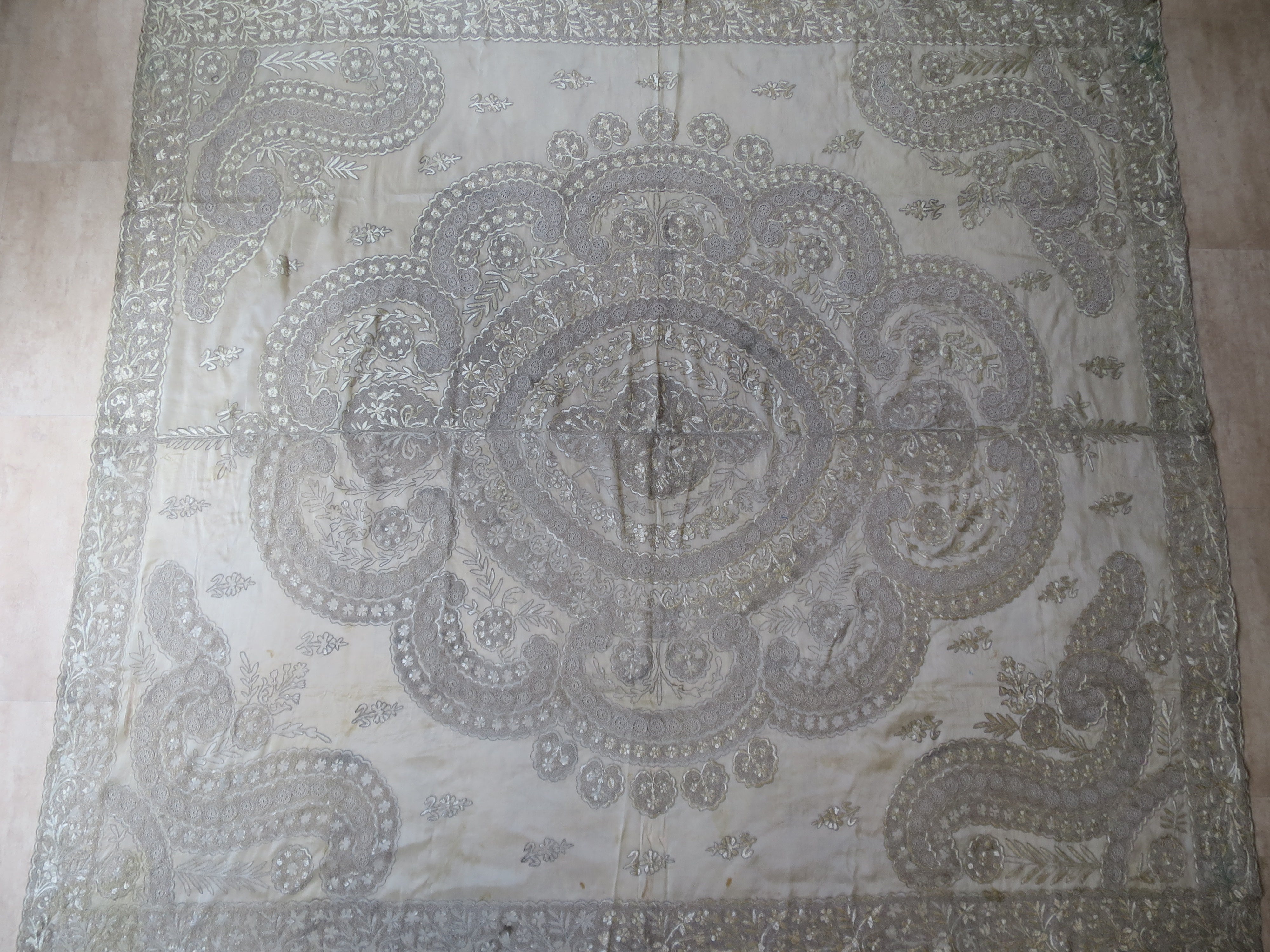 View of a 180x200cm antique Indian Zardozi panel, showing dense silver-gilt wire embroidery and a central medallion on sheer silk gauze.