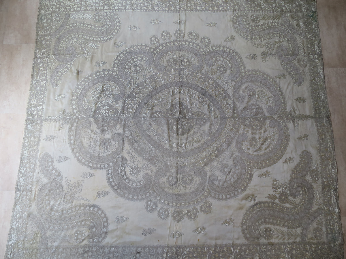 View of a 180x200cm antique Indian Zardozi panel, showing dense silver-gilt wire embroidery and a central medallion on sheer silk gauze.