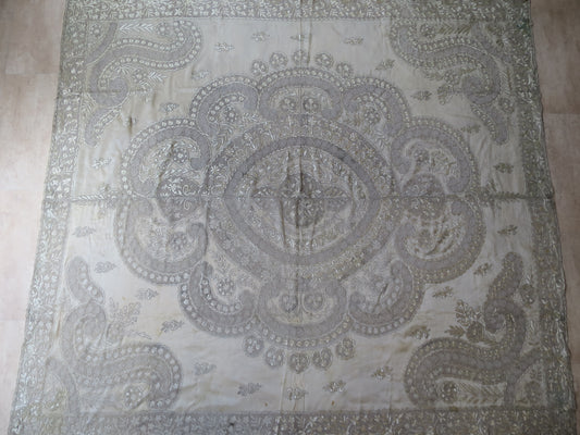 View of a 180x200cm antique Indian Zardozi panel, showing dense silver-gilt wire embroidery and a central medallion on sheer silk gauze.