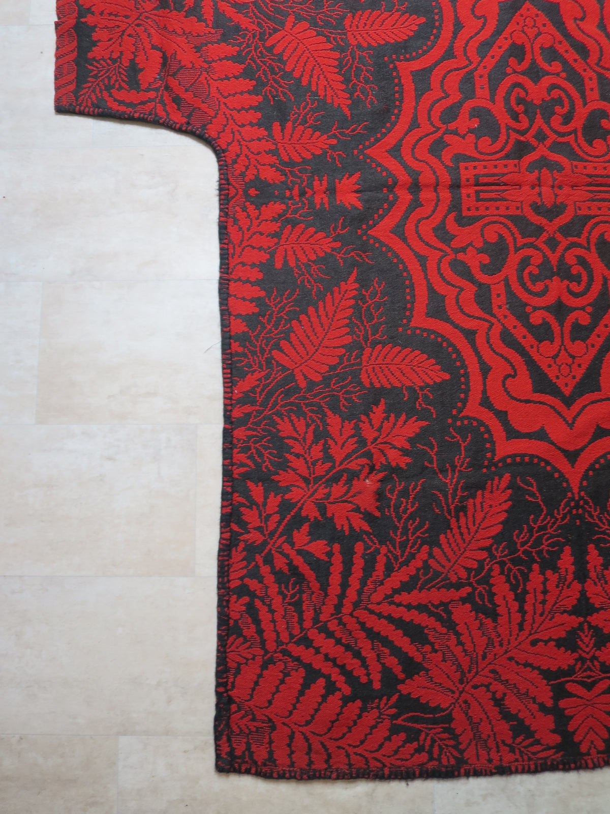 Close up of a historic bedpost cut-out on an antique blanket, showing the edge securely finished and stabilized with hand-stitched blanket stitch.
