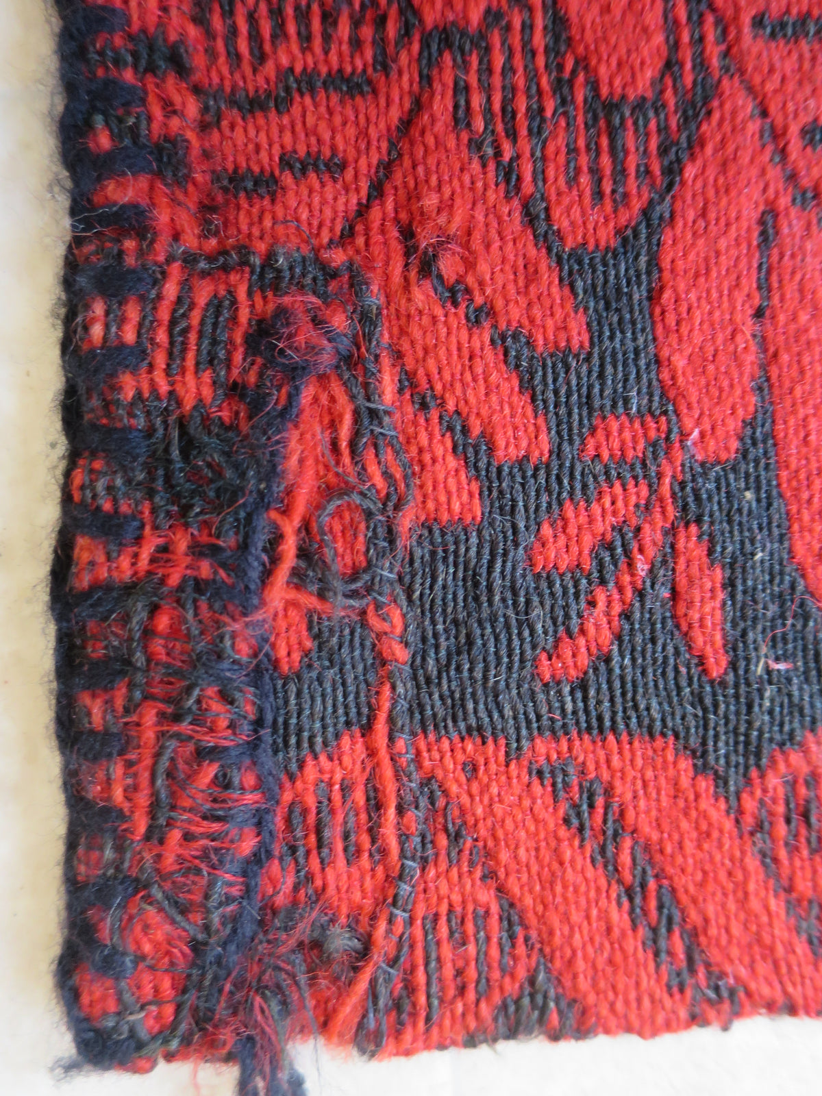Detailed view of a repair to selvedge weave on a heavy weight antique wool double-weave coverlet blanket.