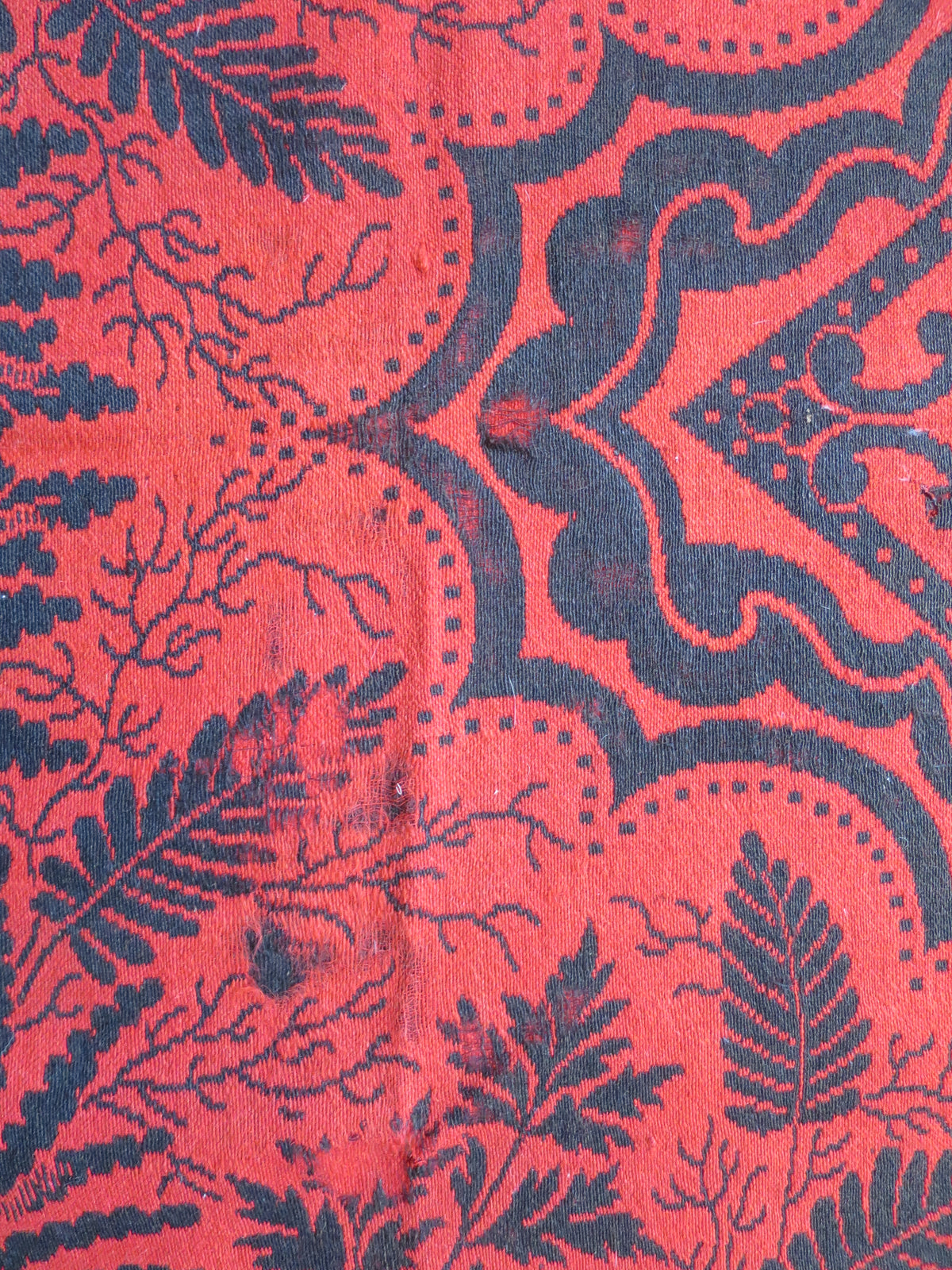 Close up texture of the hand-spun wool fibers and weave structure on a mid-19th-century American folk art textile.