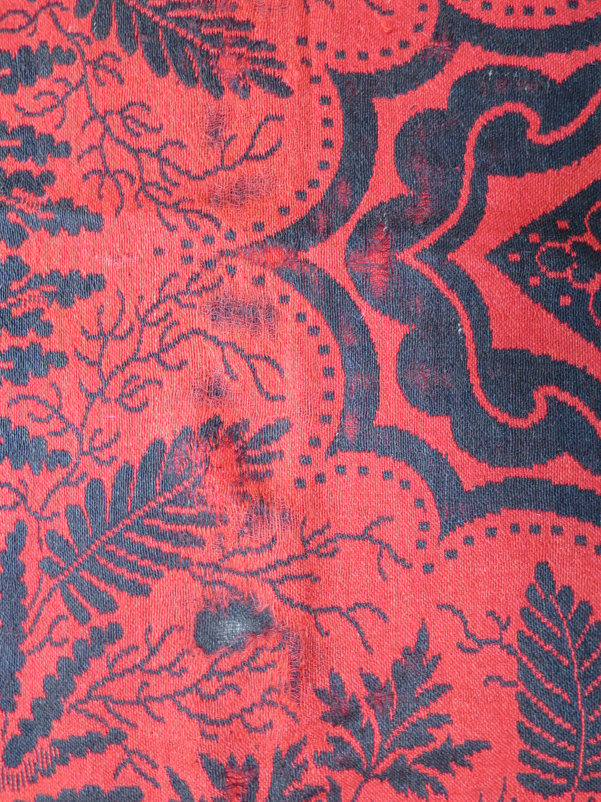 Close up texture of the hand-spun wool fibers and weave structure on a mid-19th-century American folk art textile.
