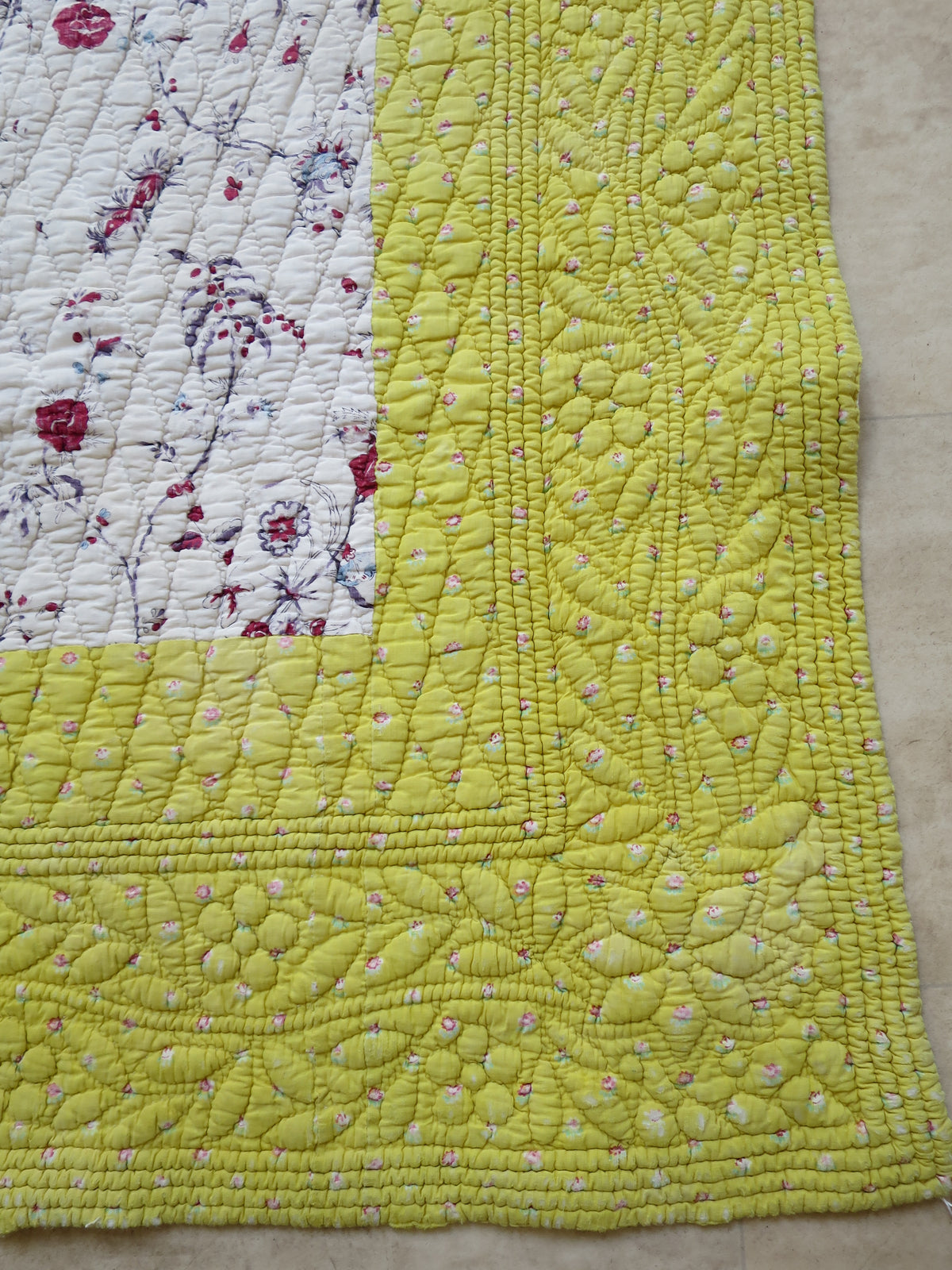 Trapunto floral running-stitch quilting detail on the sulphur-yellow border