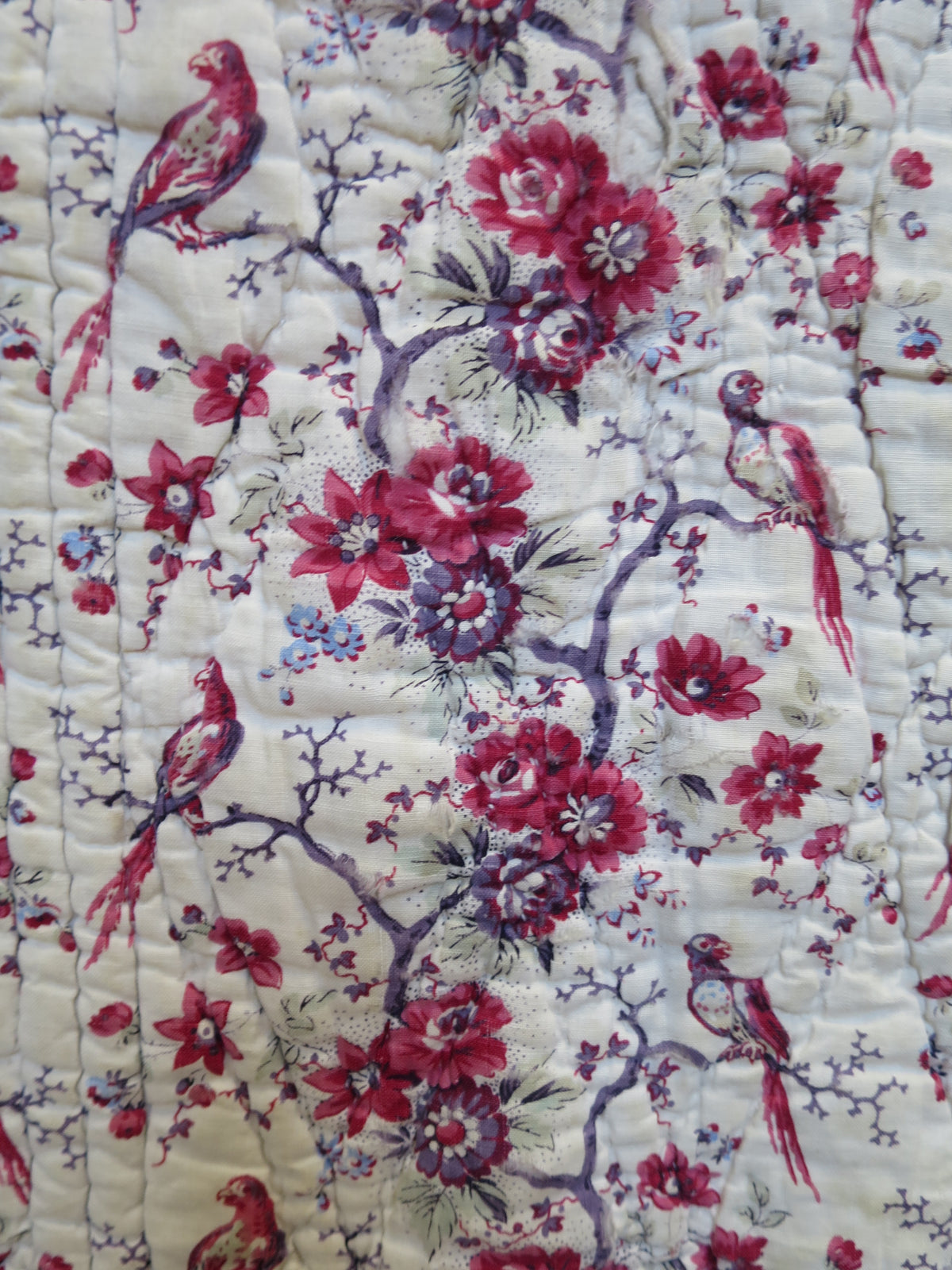 Further wear to the block-printed bird and floral fabric on the quilt’s front.