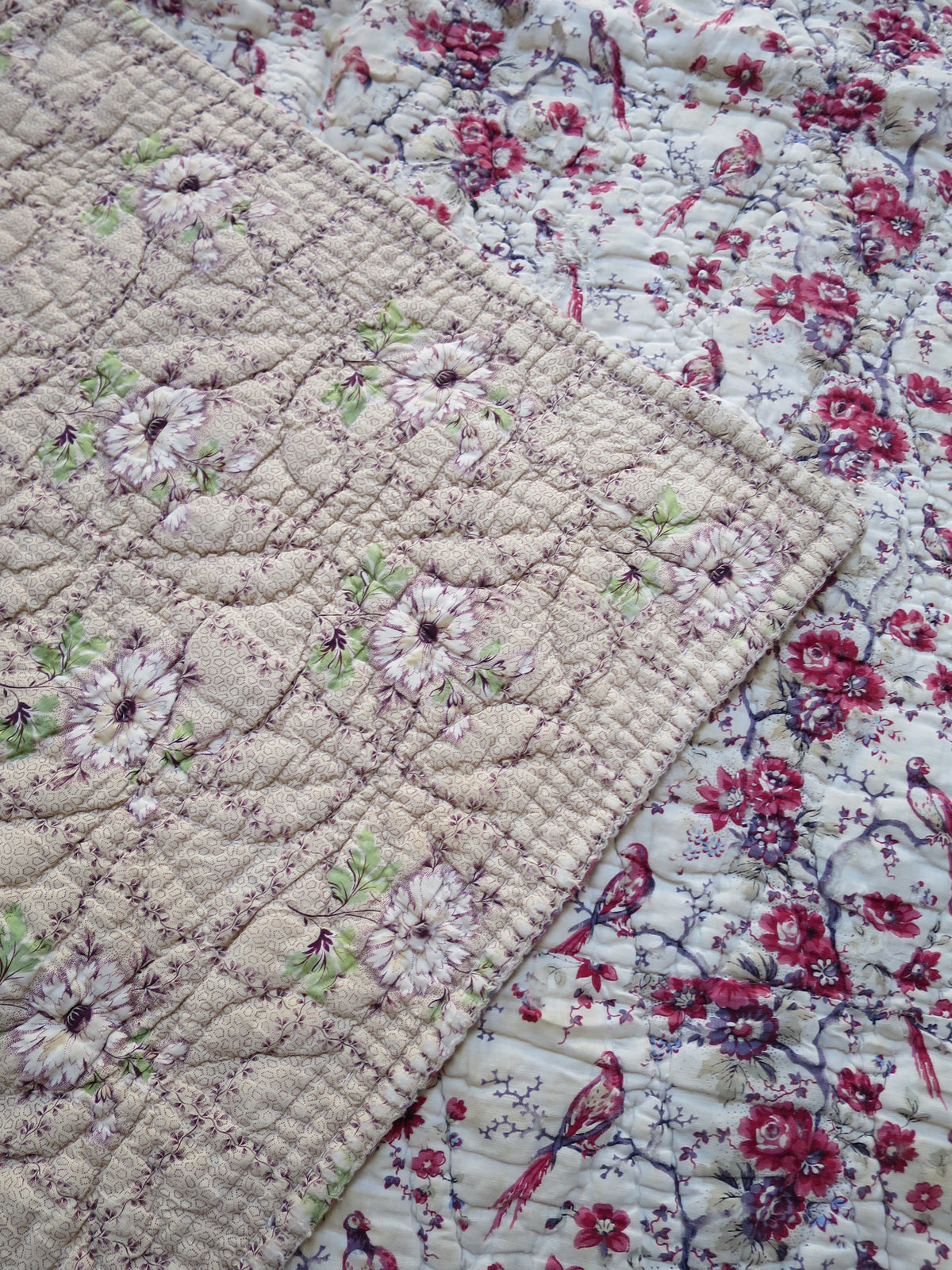 Bird-printed front folded back to show the contrasting floral reverse of the French quilt.