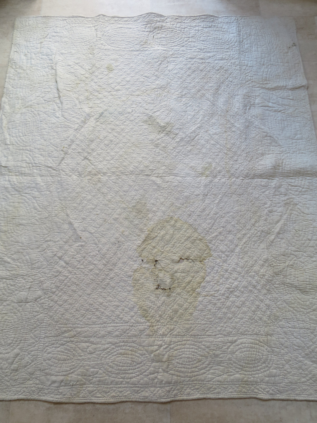 Reverse of the Provençal piqué quilt, showing its hand-quilted medallions and geometric stitching.