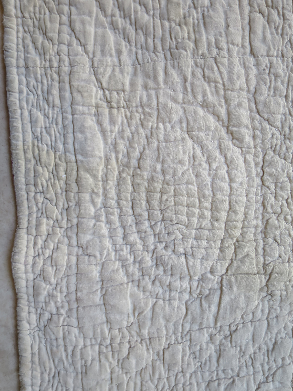 Closer view of the reverse border, showing its dense hand stitching and quilted pattern.