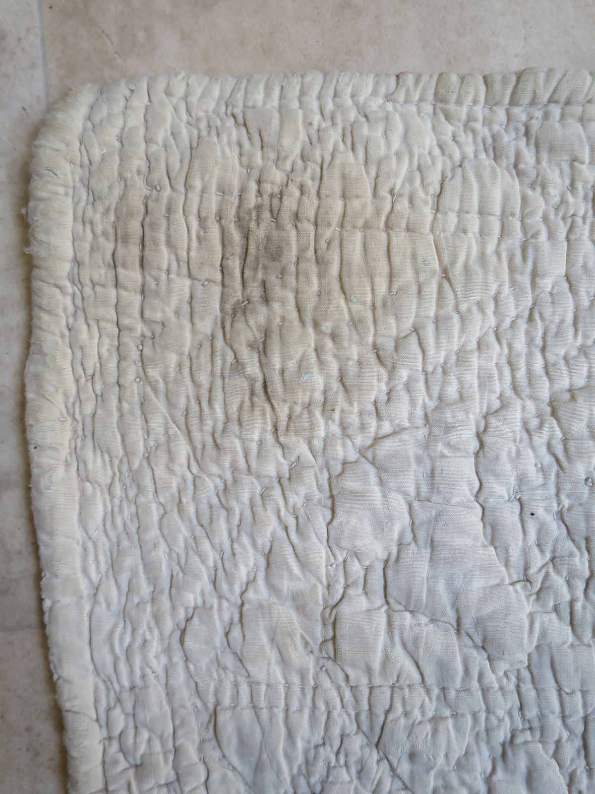 Close view of staining near a corner of the hand-quilted reverse.