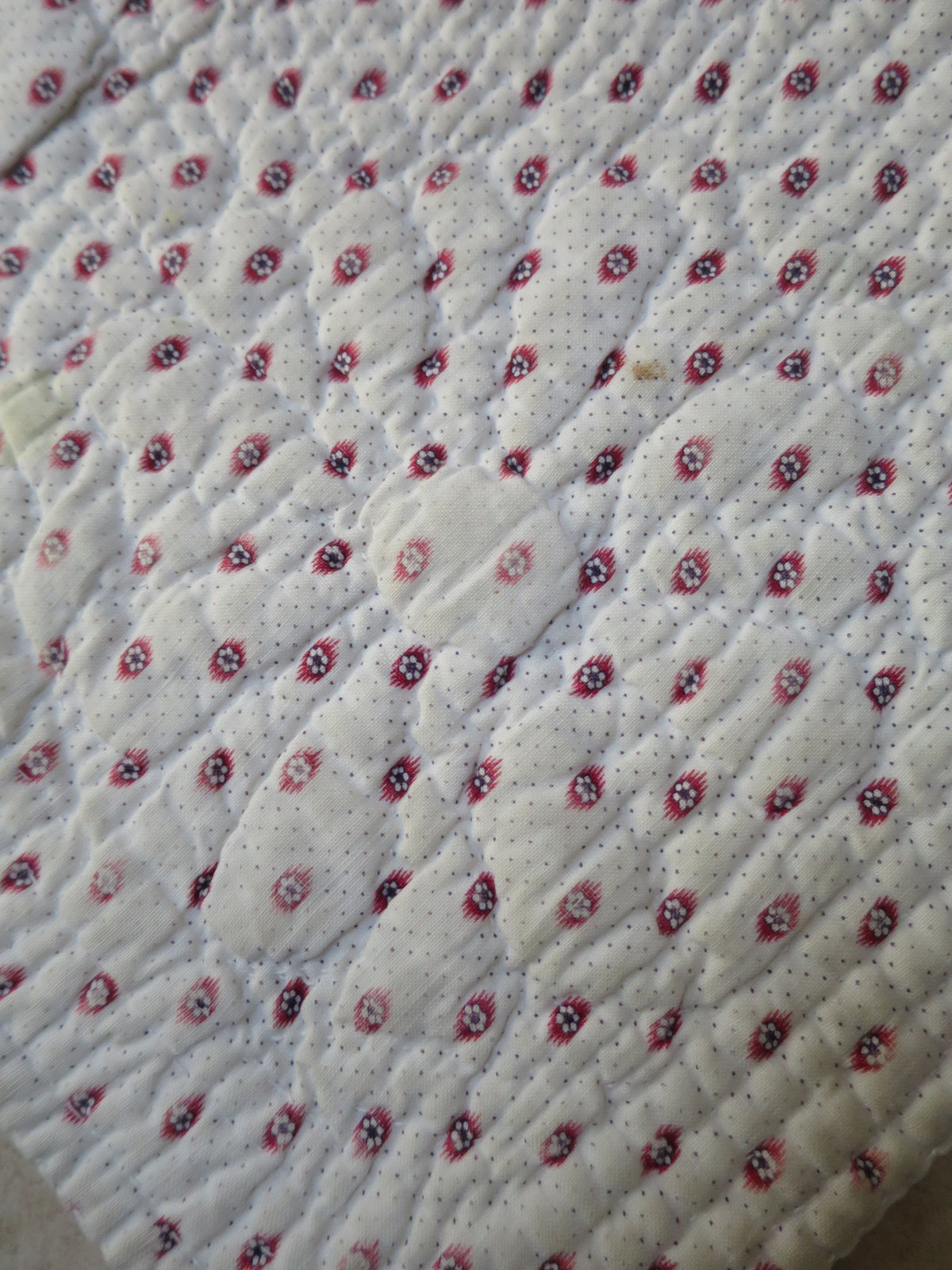 Corner detail of mignonette reverse showing quilted floral motif worked through all layers, late 18th-century French piqué quilt, c.1775–1790