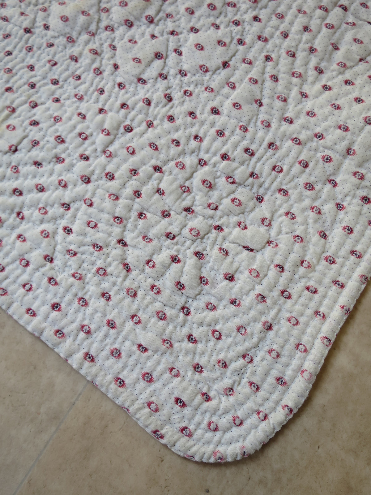 Corner detail of mignonette reverse showing quilted floral motif worked through all layers, late 18th-century French piqué quilt, c.1775–1790