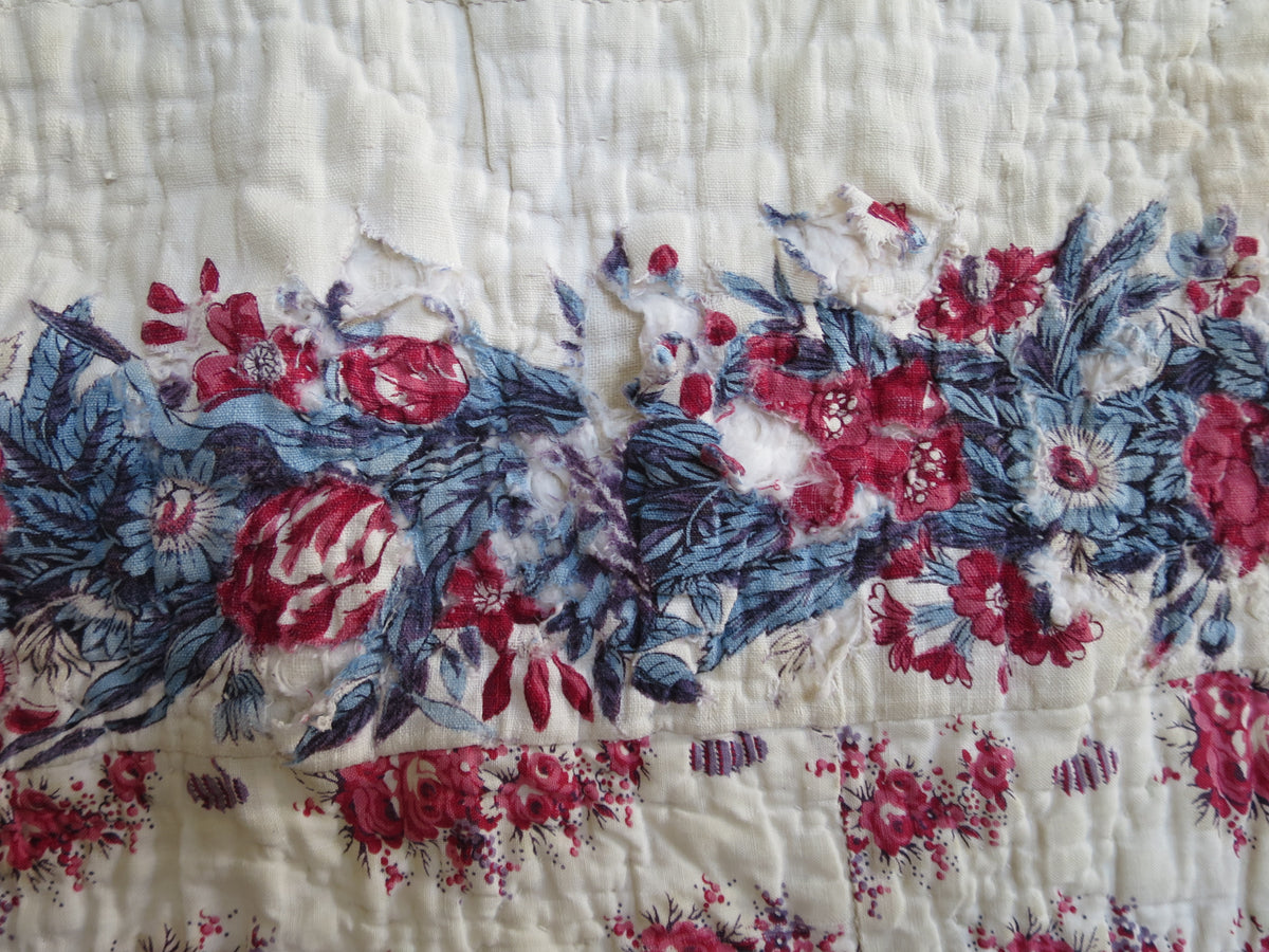 Historic wear in an area of the printed cotton on the front of the French quilt.