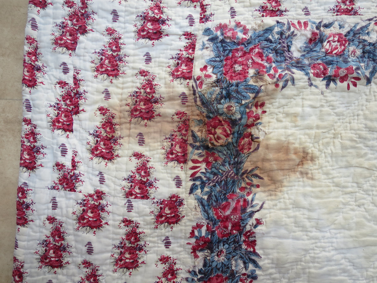 Rust-coloured staining on the printed front of the early 19th-century French quilt.