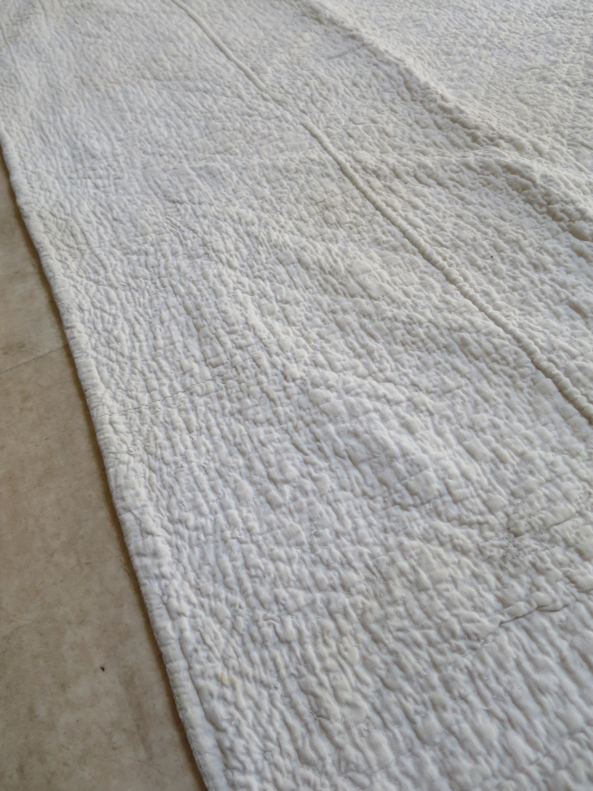 Close view of the white quilted border, showing dense stitching and raised cording.