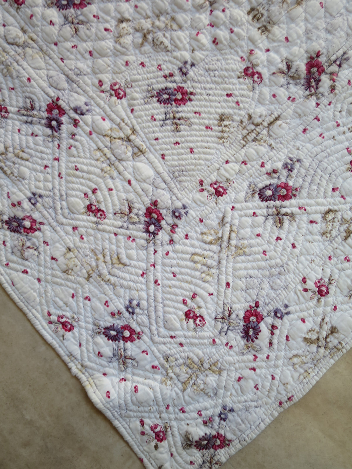 Close view of a padded heart-shaped motif at a corner of the quilt’s printed front.