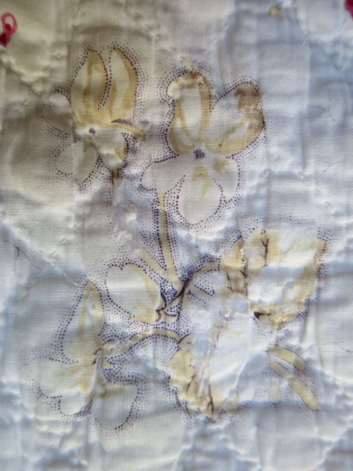 Block-printed floral sprigs in ochre with picotage on the front of the French quilt.