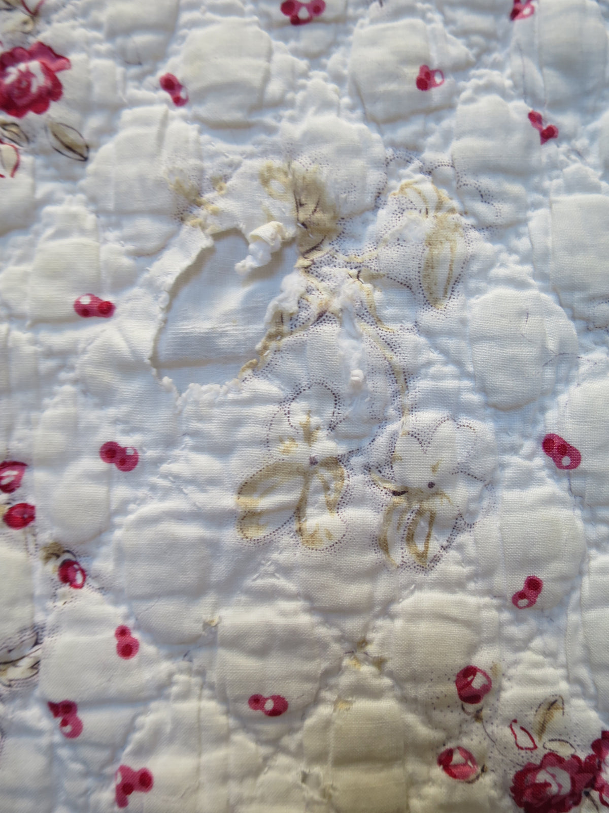 Close view of wear to the block-printed cotton on the quilt’s front face.