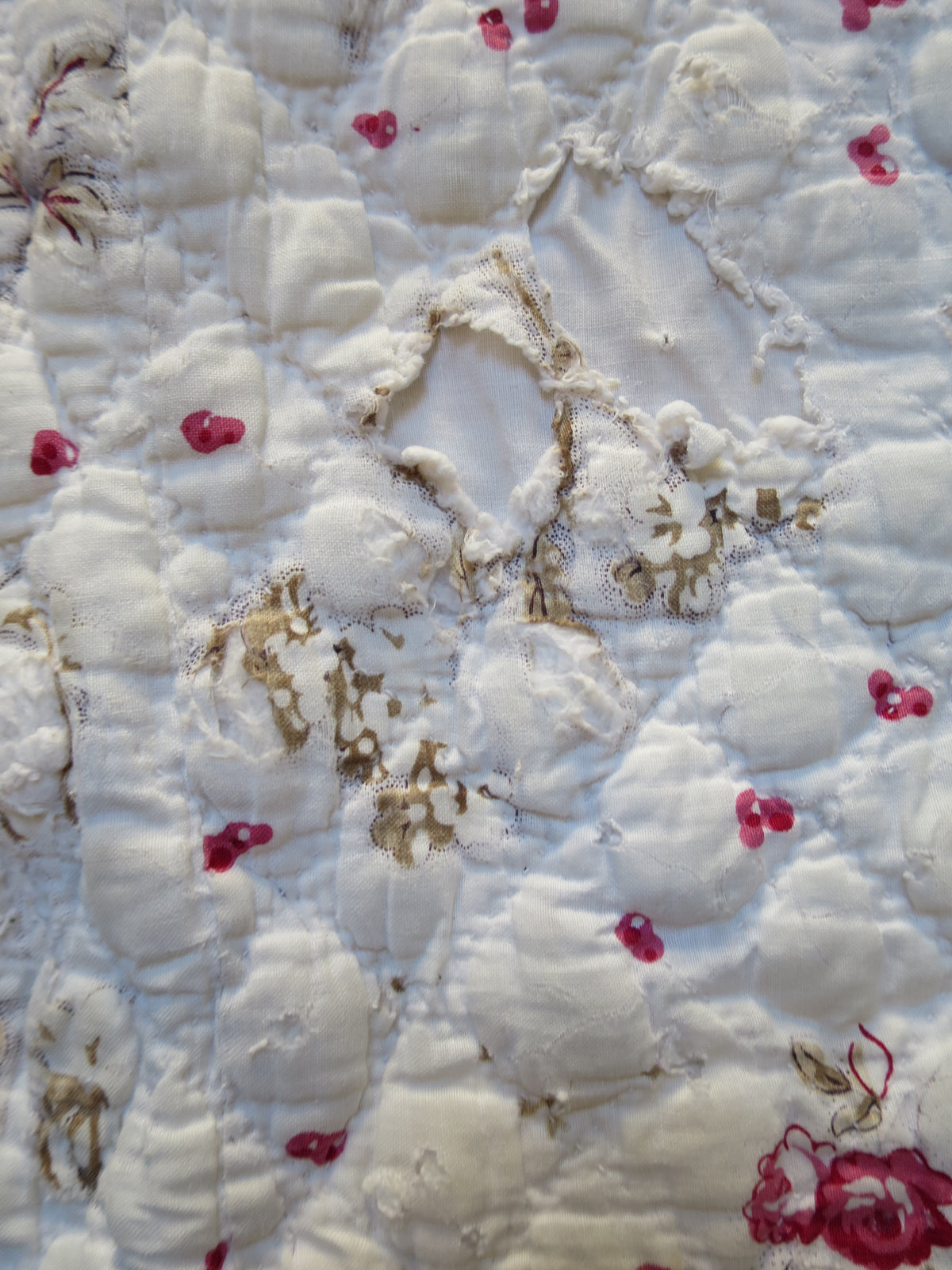 Further detail of wear on the printed front, with the surrounding quilting visible.