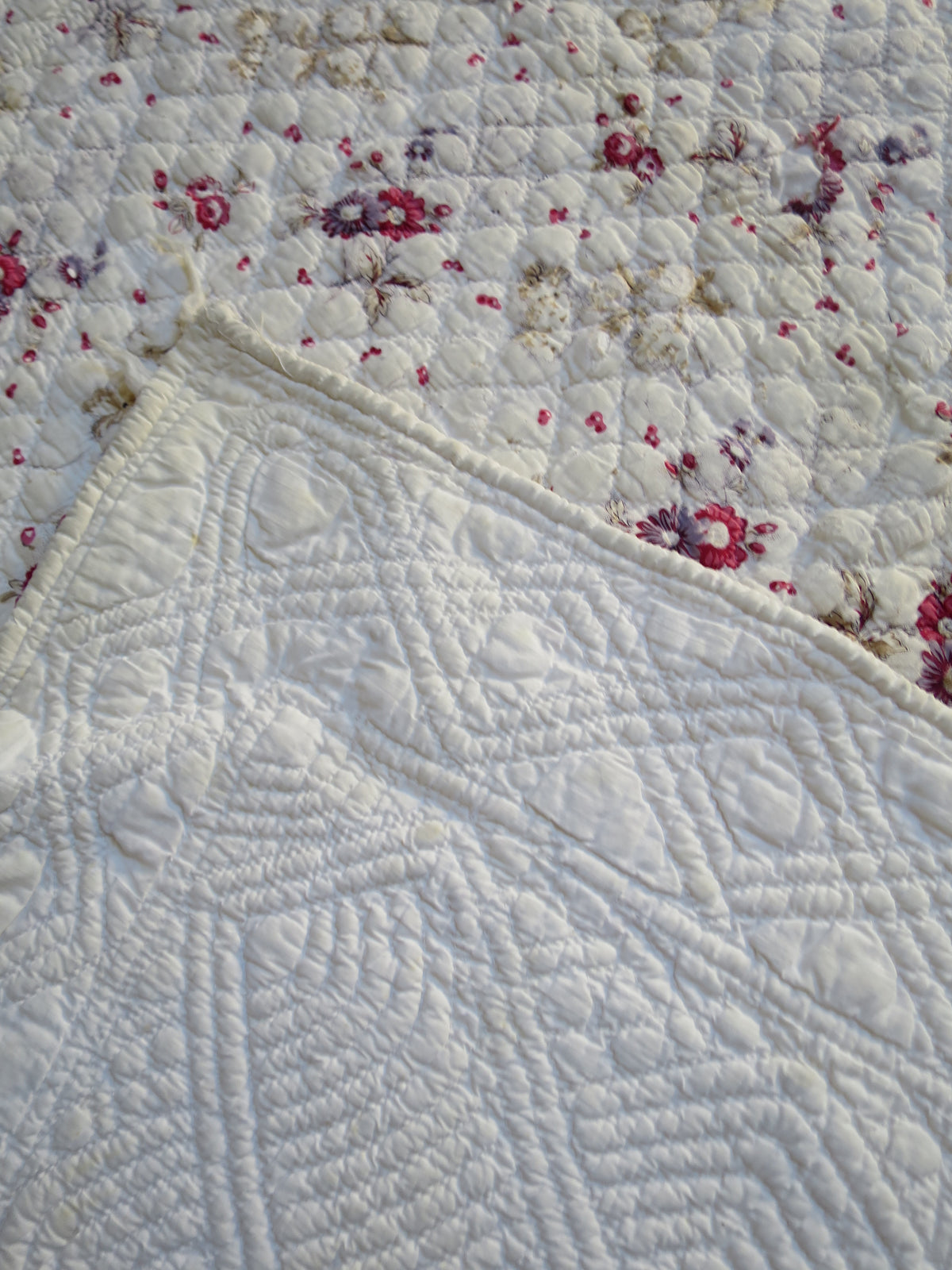 Printed front of the French quilt folded back to reveal its white corded reverse