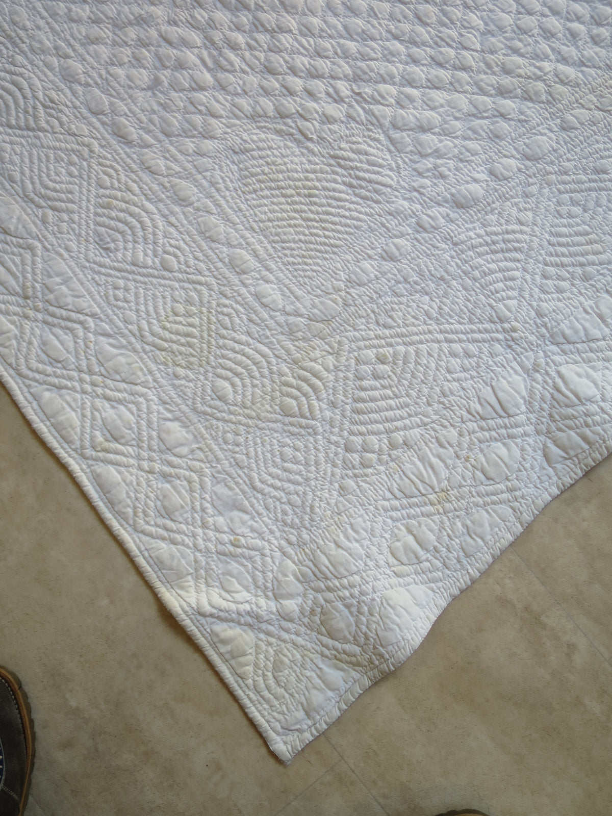 Corner of the white reverse, showing the padded heart motif and surrounding corded quilting.