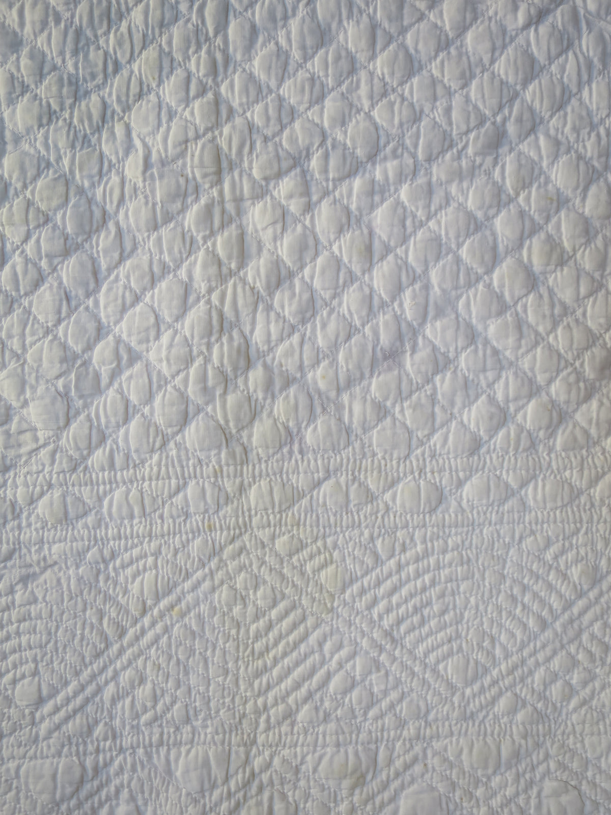 Centre and border of the white reverse, with raised channels and geometric quilting.