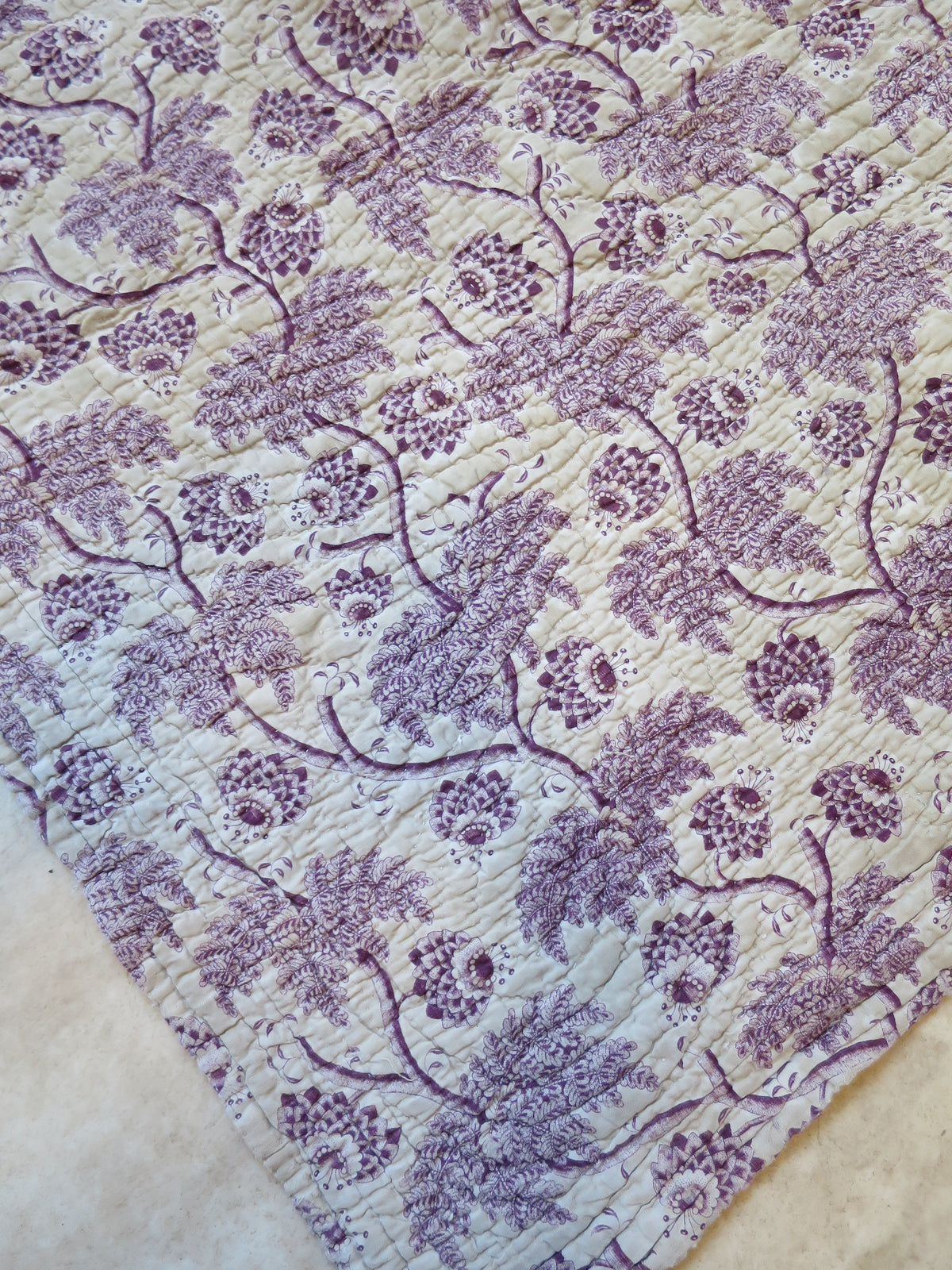 Corner detail of the plum block-printed front showing quilting detail