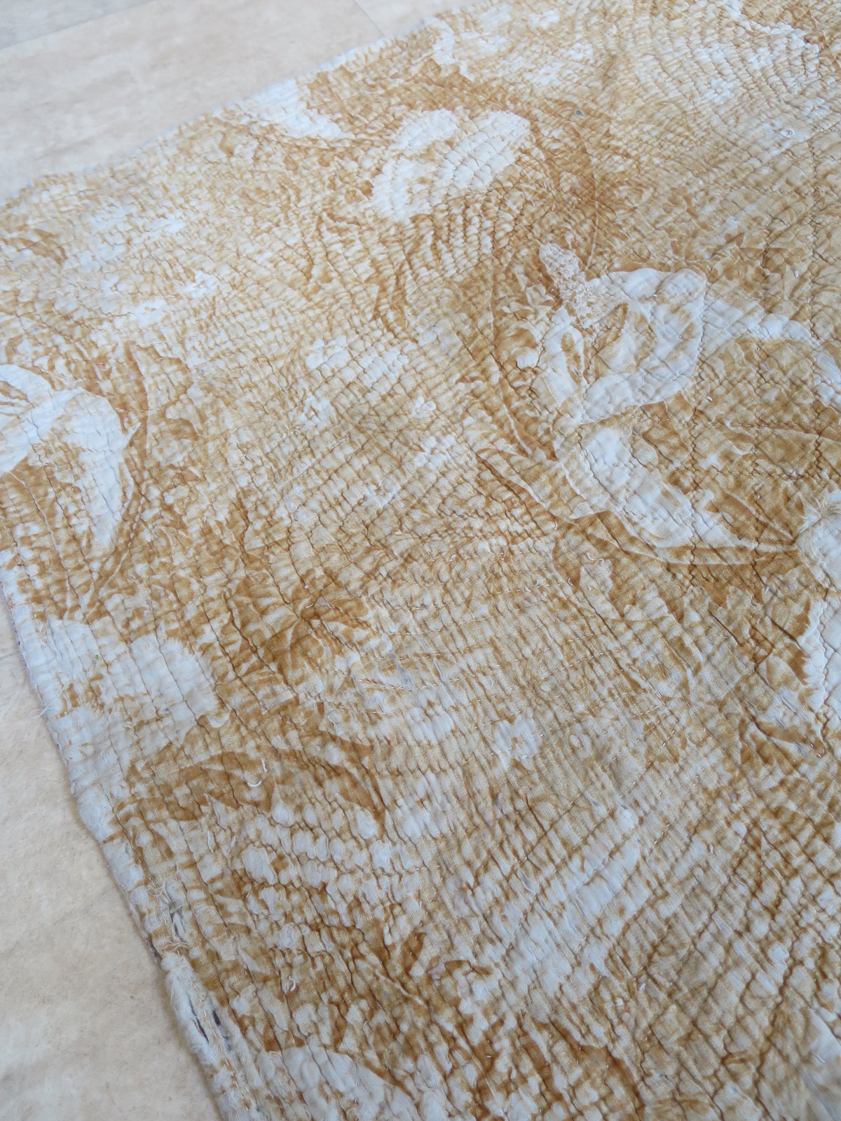 Quilted edge on the ochre reverse of the part quilt