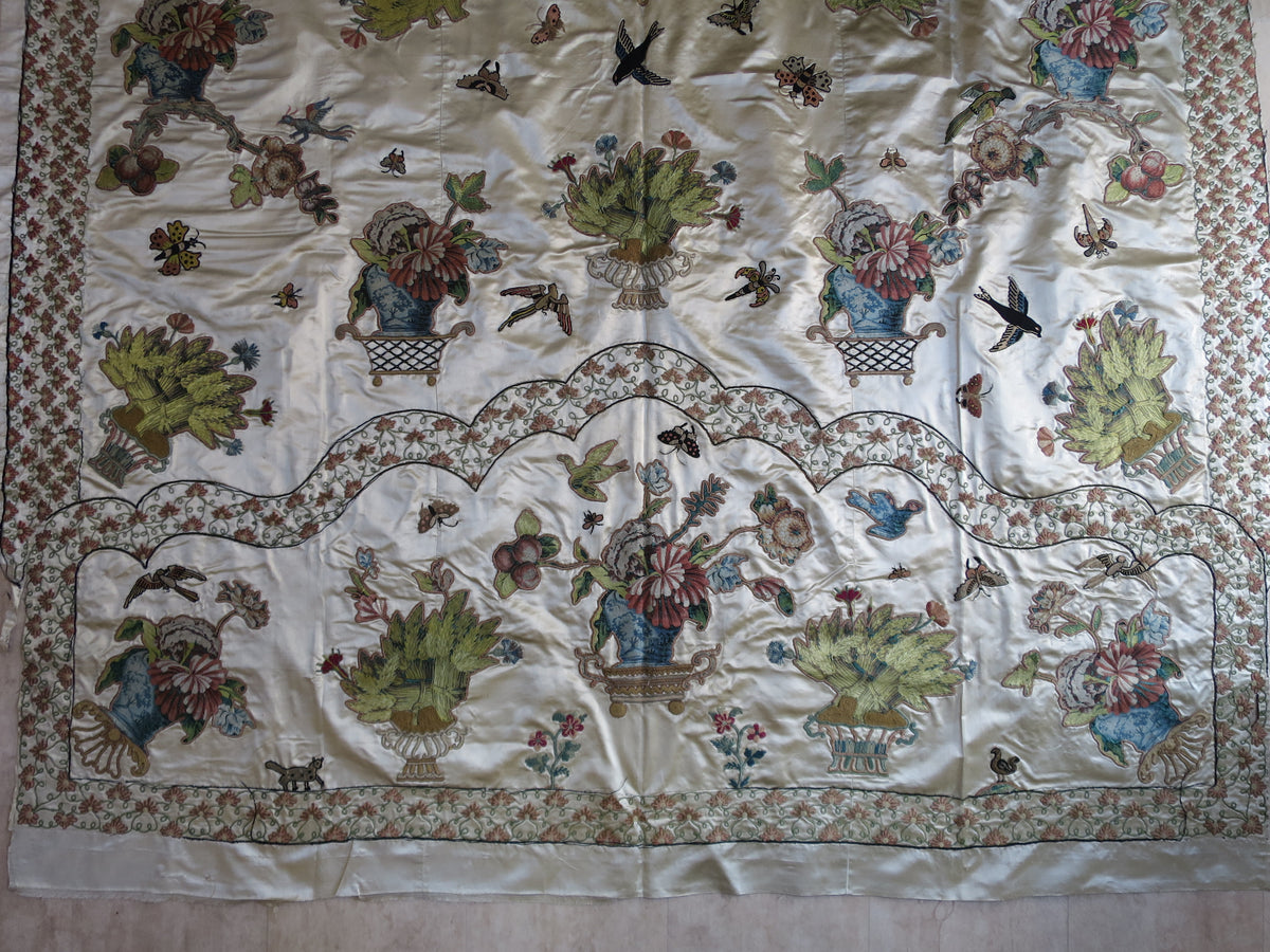 Section of the 18th-century silk coverlet, showing lampas silk appliqués on an ivory-cream satin ground.