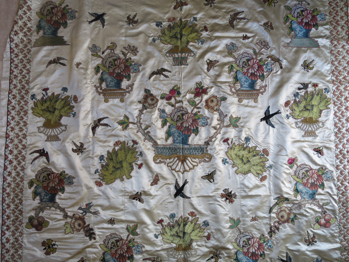 Section of the silk coverlet showing polychrome embroidery among the appliquéd motifs.