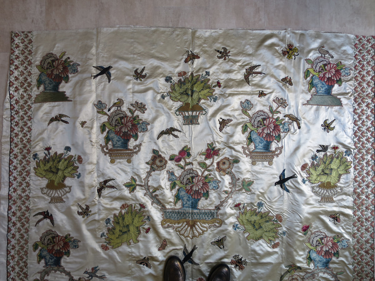 Section of the silk coverlet showing polychrome embroidery among the appliquéd motifs.