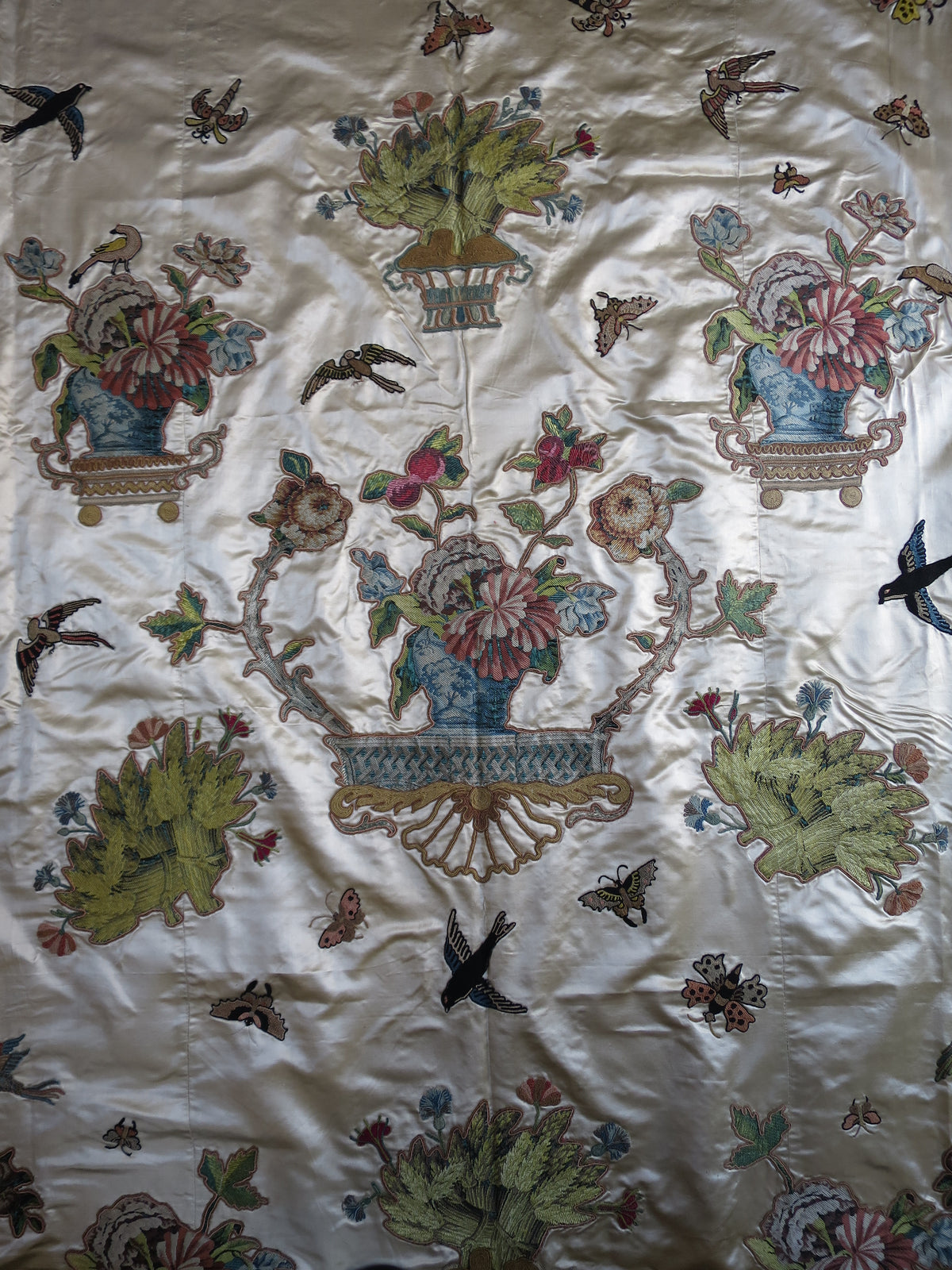 Central appliqué motif on the coverlet, cut from lampas silk and mounted on the satin ground.