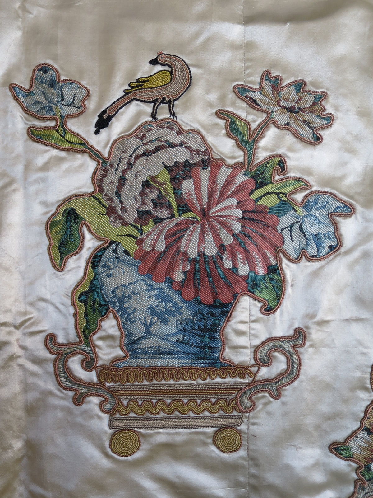 Detail of a lampas silk appliqué motif with embroidery on the Georgian coverlet.