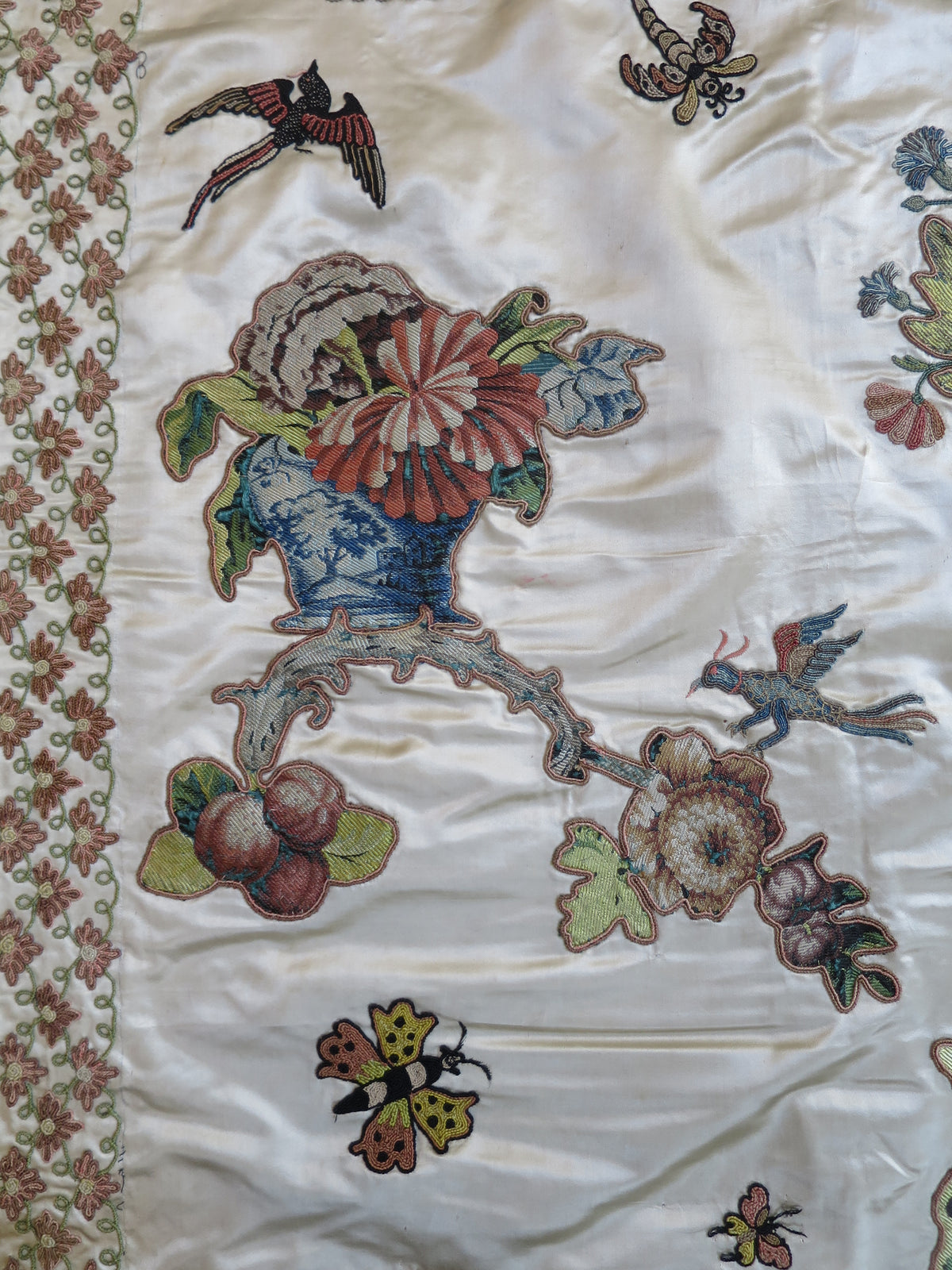 Close view of a cut lampas silk appliqué motif on the English coverlet.