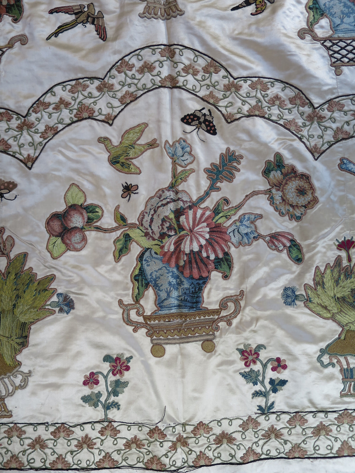 Lower section of the coverlet showing appliqué motifs and embroidery.