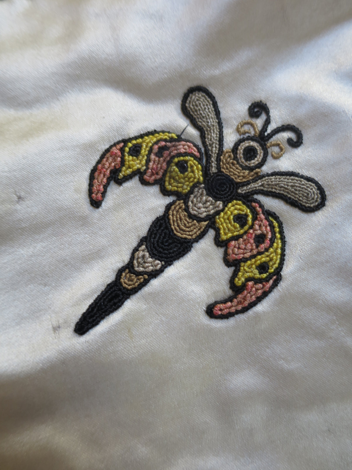 Slip-style appliqué motif, cut from lampas silk and mounted on the coverlet.