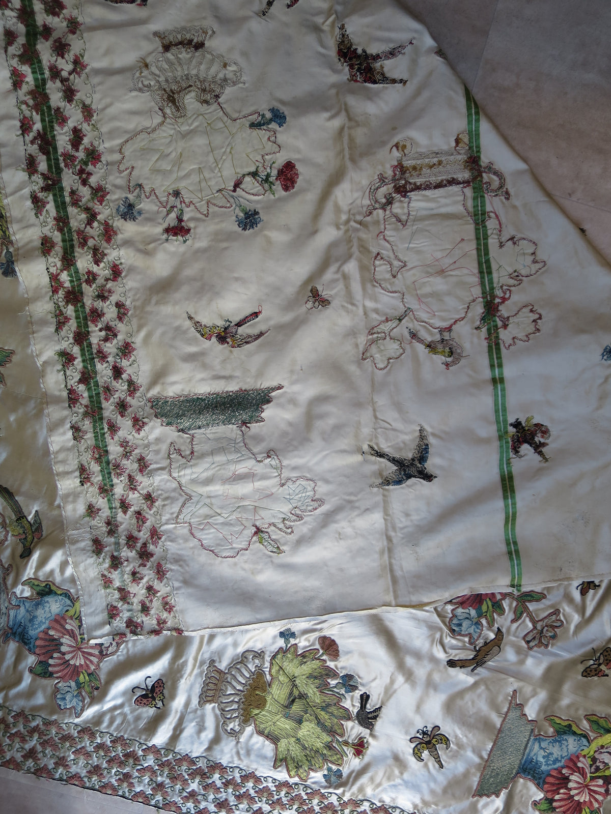 Coverlet folded to show its unbacked reverse and embroidery workings.
